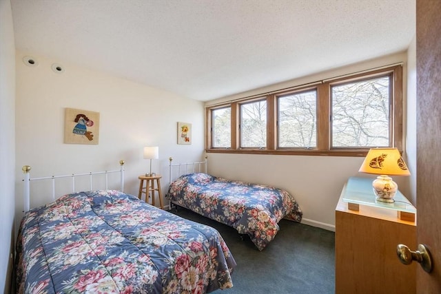 carpeted bedroom with baseboards and a textured ceiling