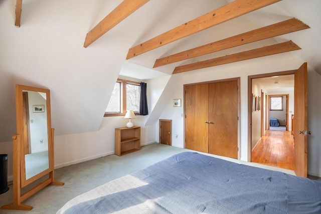 unfurnished bedroom with baseboards, vaulted ceiling with beams, and carpet