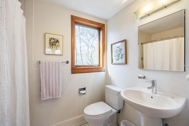 bathroom with a shower with curtain, toilet, and a sink