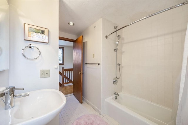 full bath with tile patterned flooring, shower / bathtub combination with curtain, baseboards, and a sink