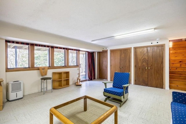 living area with tile patterned floors and a textured ceiling