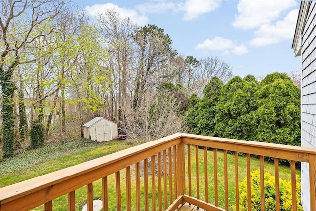 wooden terrace with an outdoor structure, a lawn, and a storage unit