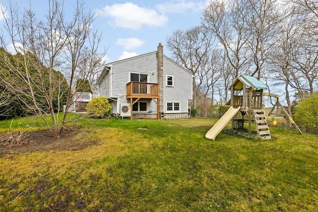 back of house with a chimney, a yard, a playground, and ac unit