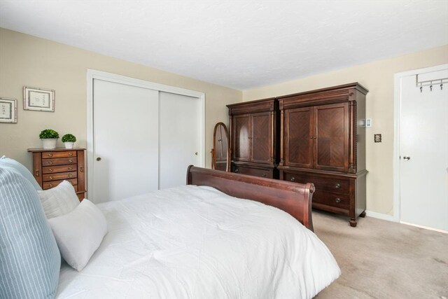 300 Falmouth Rd Unit 12E, Mashpee, MA 02649 - bedroom with light colored carpet, a closet, and baseboards