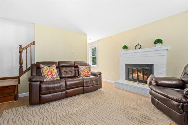 300 Falmouth Rd Unit 12E, Mashpee, MA 02649 - living area featuring a brick fireplace, stairs, and baseboards