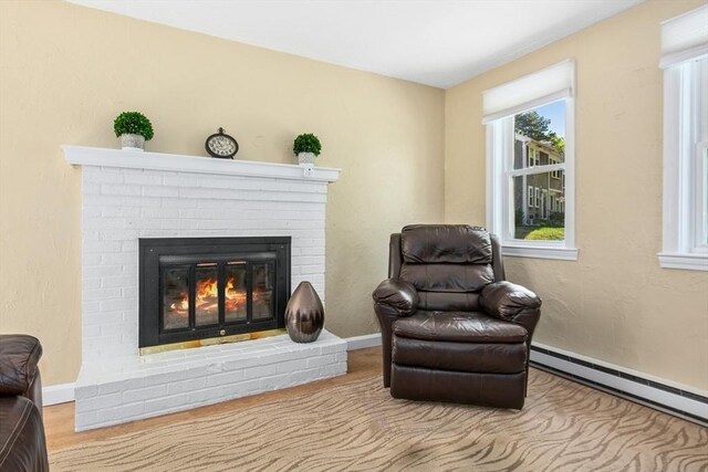 300 Falmouth Rd Unit 12E, Mashpee, MA 02649 - living area with a brick fireplace, a baseboard radiator, and baseboards