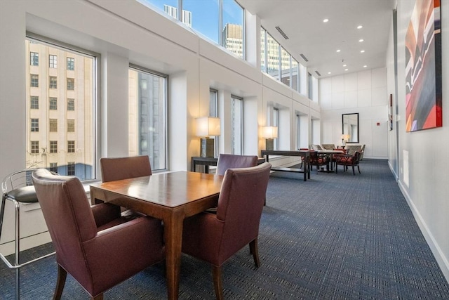 carpeted dining room with a towering ceiling