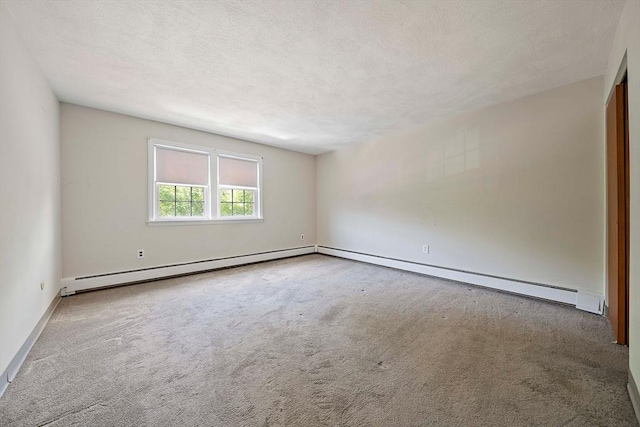 spare room with baseboards, carpet flooring, and a baseboard radiator
