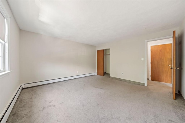 interior space with baseboard heating and light colored carpet