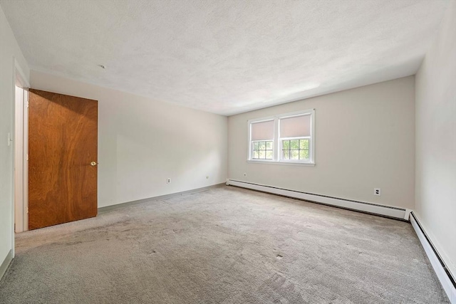 empty room featuring a baseboard radiator, carpet floors, and baseboards