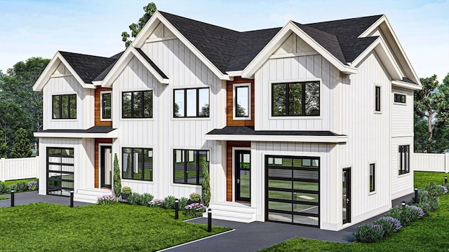 modern inspired farmhouse with a shingled roof, a front yard, and board and batten siding