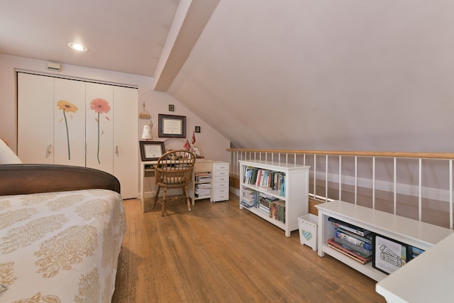 bedroom with a closet, lofted ceiling, and hardwood / wood-style floors