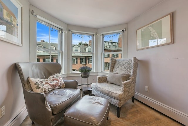 sitting room featuring baseboard heating and hardwood / wood-style flooring