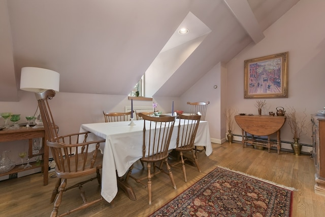 dining space with lofted ceiling, baseboard heating, and wood-type flooring