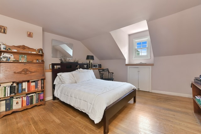 bedroom with light wood-type flooring and lofted ceiling