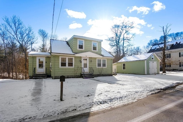 bungalow-style home featuring entry steps, a detached garage, and an outdoor structure