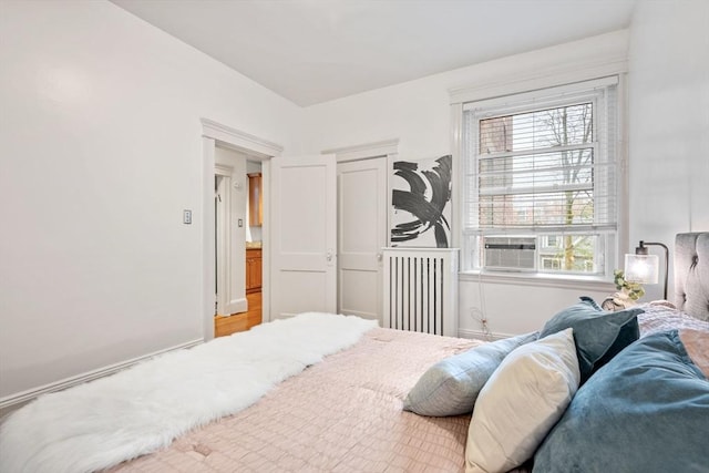 bedroom featuring radiator heating unit and baseboards