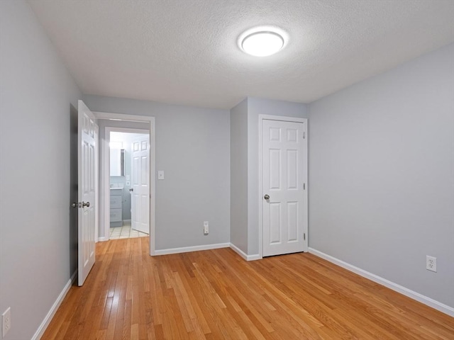 48 Decarolis Dr Unit 48, Tewksbury, MA 01876 - unfurnished bedroom featuring light wood-style floors and a textured ceiling