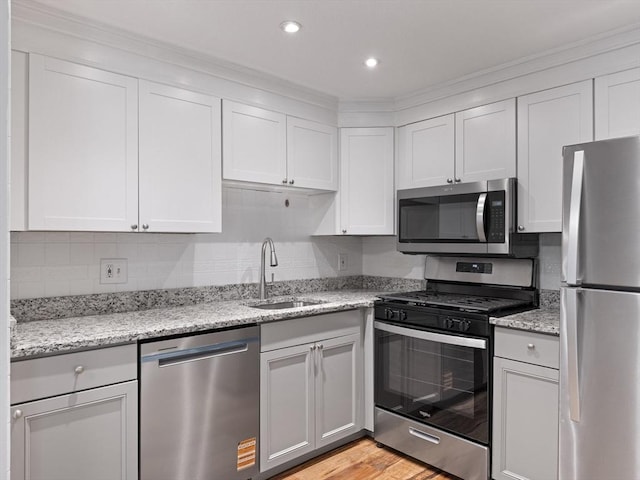 48 Decarolis Dr Unit 48, Tewksbury, MA 01876 - kitchen featuring appliances with stainless steel finishes, light stone counters, light wood finished floors, backsplash, and recessed lighting