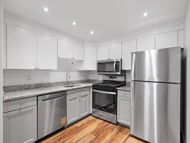 48 Decarolis Dr Unit 48, Tewksbury, MA 01876 - kitchen featuring appliances with stainless steel finishes, light wood-style flooring, light stone countertops, recessed lighting, and white cabinets