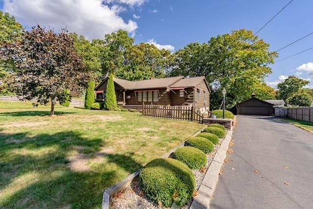 log cabin with an outdoor structure, a front yard, and a garage