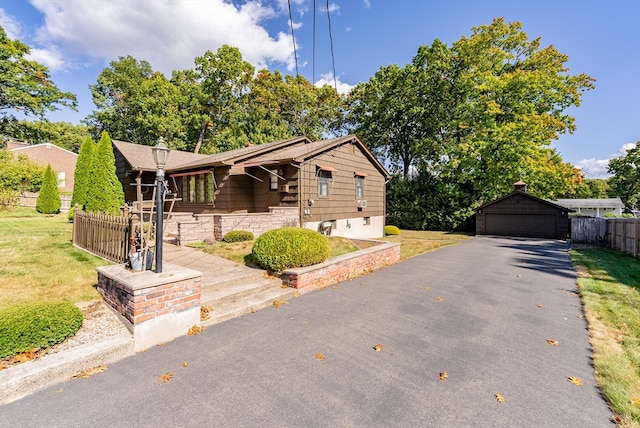 view of front of property featuring an outbuilding, a front yard, and a garage