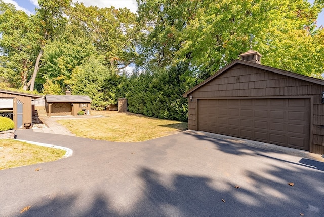 exterior space featuring a garage and an outbuilding