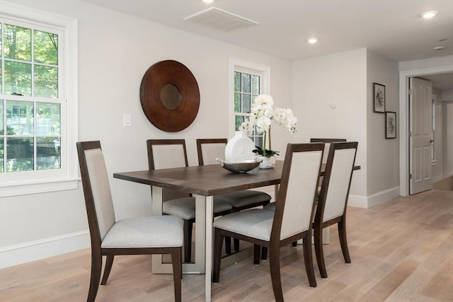 dining room with light wood finished floors, baseboards, and recessed lighting