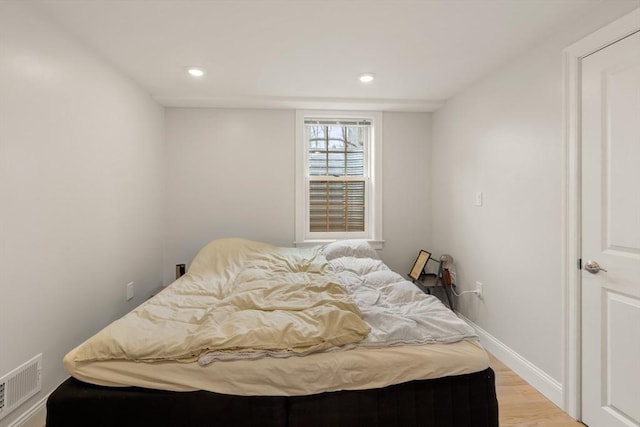 bedroom featuring light wood finished floors, recessed lighting, and baseboards