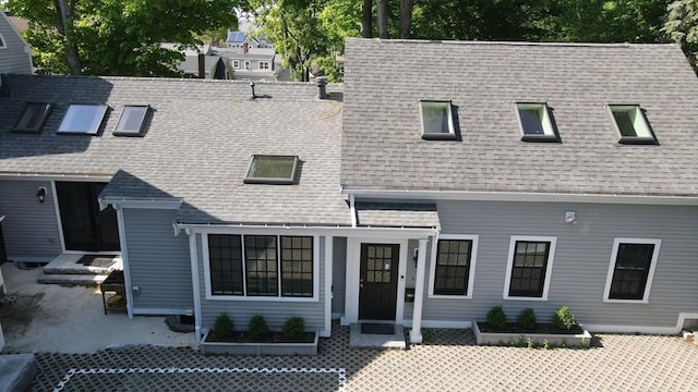 view of front facade with roof with shingles