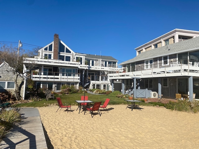 back of property with a patio, a lawn, and a balcony