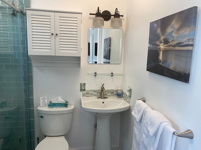 bathroom featuring tiled shower and toilet