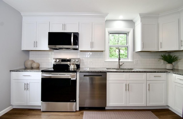63 Grandview St, Springfield, MA 01118 - kitchen featuring appliances with stainless steel finishes, a sink, white cabinetry, stone counters, and wood finished floors