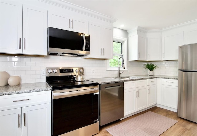 63 Grandview St, Springfield, MA 01118 - kitchen featuring stainless steel appliances, a sink, white cabinetry, light wood finished floors, and light stone counters