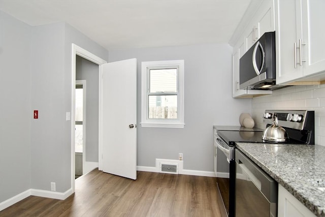 63 Grandview St, Springfield, MA 01118 - kitchen featuring stainless steel appliances, dark wood finished floors, decorative backsplash, white cabinetry, and light stone counters