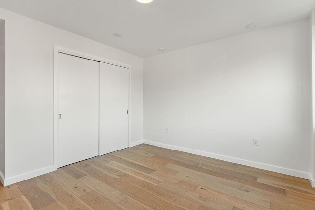 unfurnished bedroom with light hardwood / wood-style floors and a closet