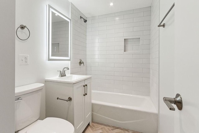 full bathroom featuring tiled shower / bath, vanity, and toilet