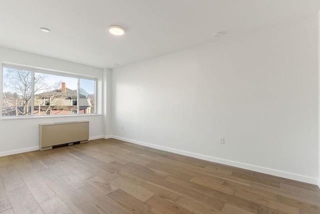 unfurnished room featuring radiator and wood-type flooring