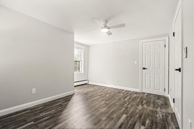 spare room with dark hardwood / wood-style flooring, baseboard heating, and ceiling fan