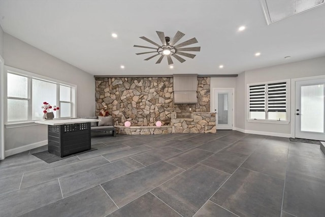 unfurnished living room featuring ceiling fan and a healthy amount of sunlight