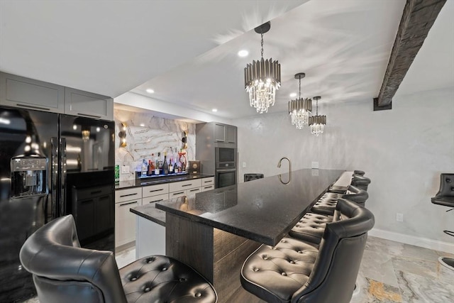 kitchen with a center island, a kitchen bar, gray cabinets, beamed ceiling, and black fridge with ice dispenser