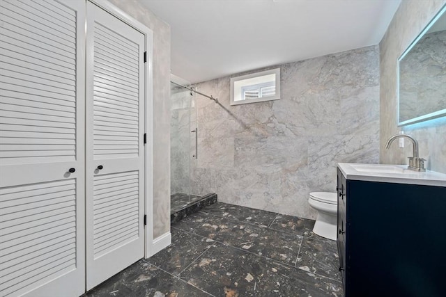 bathroom featuring a tile shower, vanity, and toilet