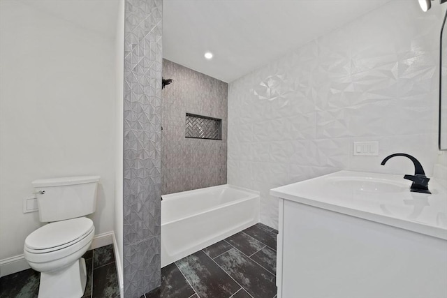 bathroom featuring vanity, toilet, and tile walls