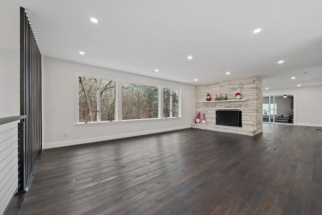 unfurnished living room featuring a fireplace and dark wood-type flooring