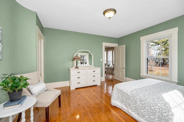 bedroom with light wood finished floors and baseboards