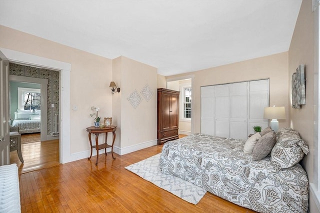 bedroom featuring a closet, baseboards, and light wood-style floors