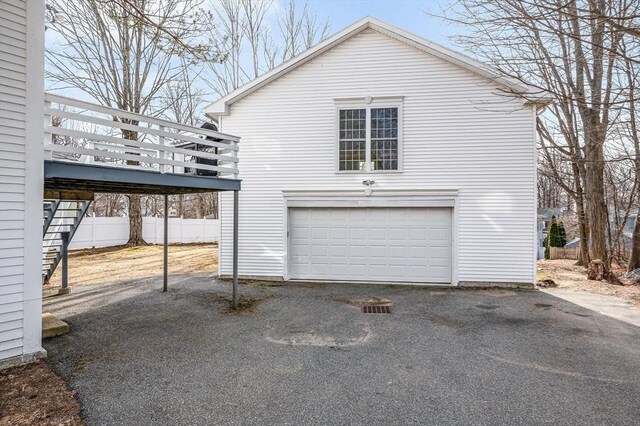 view of home's exterior featuring a wooden deck, stairs, a garage, and fence