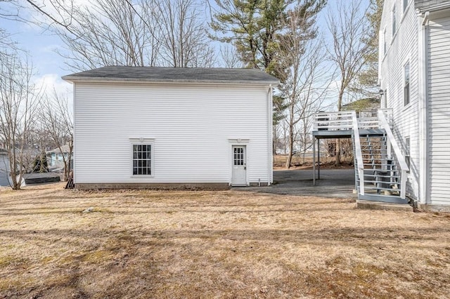 exterior space with a deck, stairway, and a yard