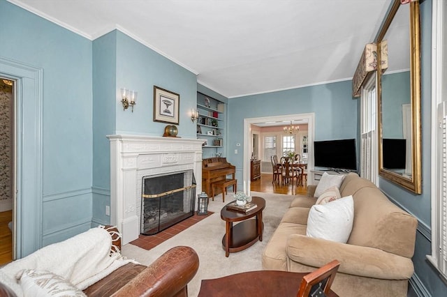 living area with crown molding, a brick fireplace, and built in shelves