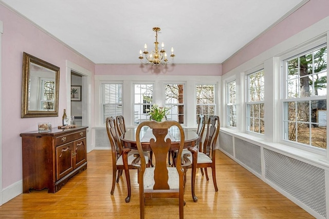 dining room with baseboards, plenty of natural light, light wood-style floors, and a chandelier